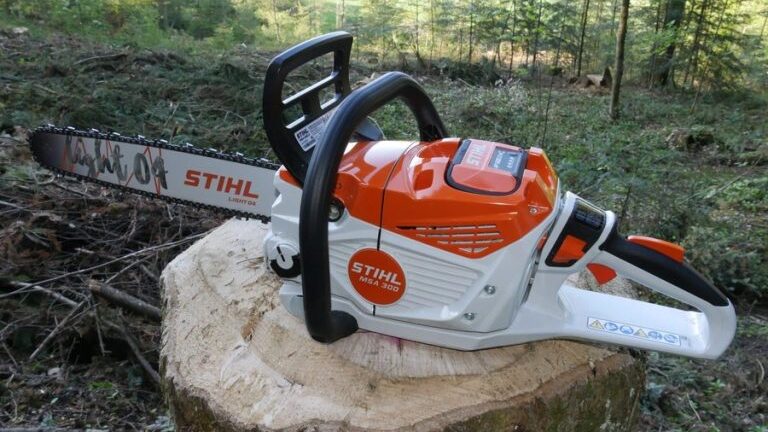 La tronçonneuse stihl MSA 300 est posée sur une souche d'arbre dans une forêt