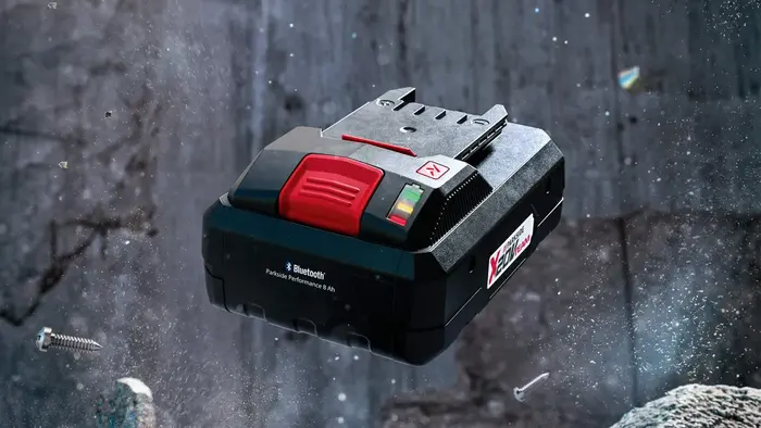 Une batterie smart parkside présentée devant un décor d'ardoises avec effets de poussière flouté