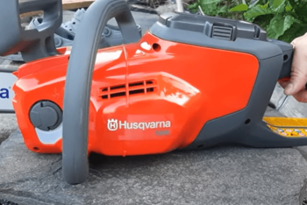 Tronçonneuse-à-batterie-husqvarna-posée-sur-une-table-de-jardin